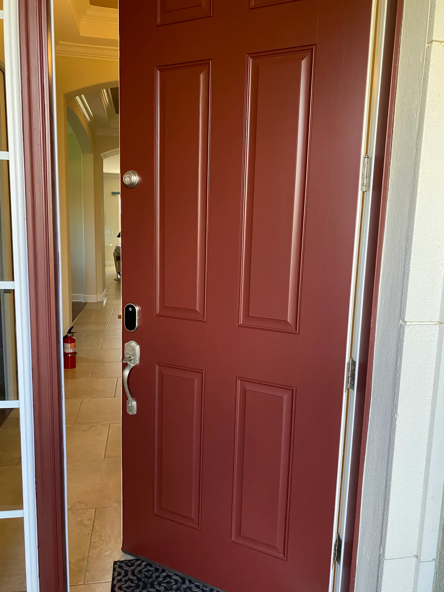 Freshly painted deep burgundy six-panel interior door with crisp white trim
